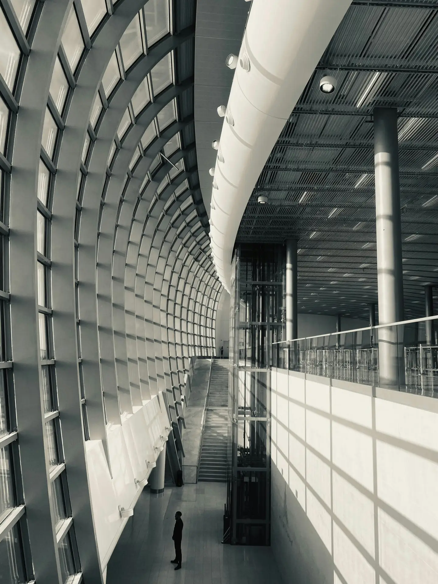 a black and white photo of a person in a large building