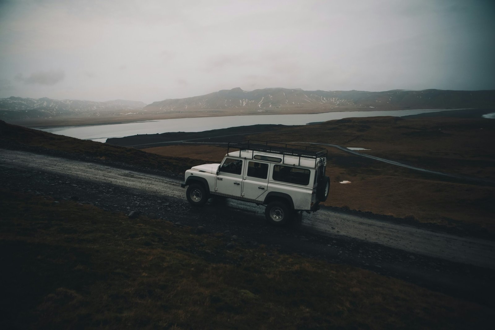 white sport utility vehicle running on road near field